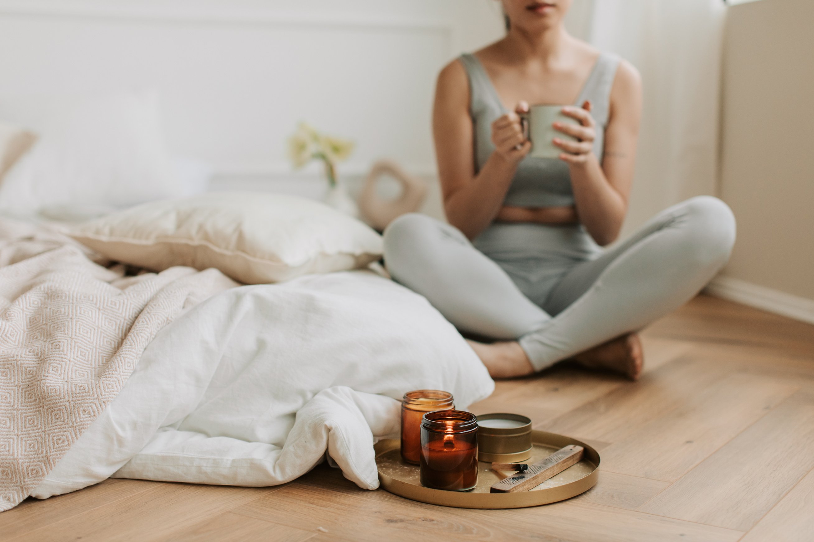 Woman Having Cup of Tea with Lighted Candles Near Her